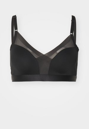 Black bra with a seamless design, featuring a combination of smooth fabric and sheer mesh panels. Adjustable straps and a wide band.