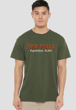 Olivgrünes Baumwoll-T-Shirt mit der Aufschrift "TWIN PEAKS Bevölkerung 51.201" in kontrastierendem Rot und Weiß. Kurzärmlig, mit Rundhalsausschnitt.