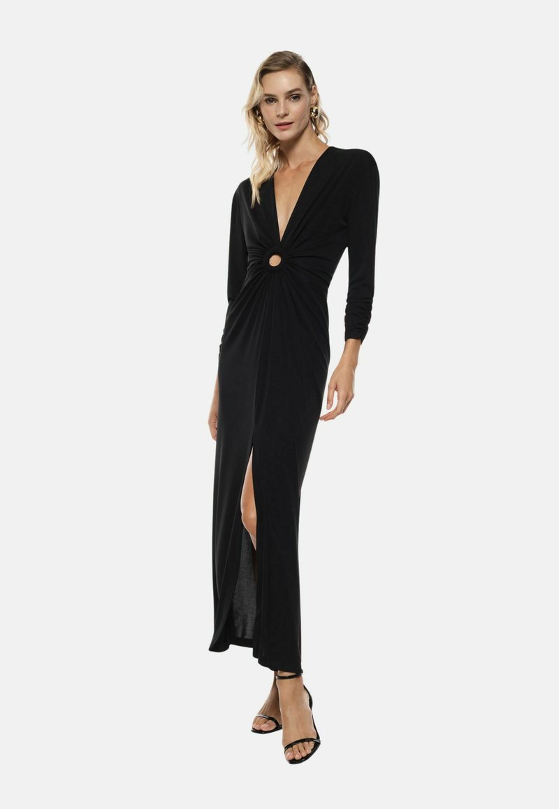 Abito lungo nero a maniche lunghe con profonda scollatura a V, frontale intrecciato con un'apertura circolare e uno spacco alto fino alla coscia. Tessuto liscio e silhouette aderente.