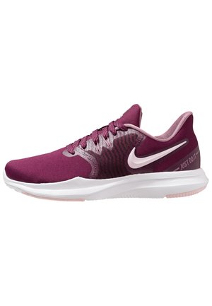 Bordowo-różowy but do biegania Nike z białą podeszwą, wiązaniem na sznurówki i tekstem "Just Do It" na bocznej stronie pięty.