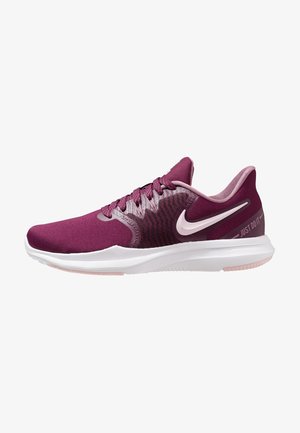 Chaussure de running Nike bordeaux et rose avec semelle blanche, design à lacets et texte "Just Do It" sur le côté du talon.