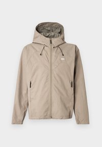 Μπεζ ζακέτα με φερμουάρ και κουκούλα, με καμπύλη ραφή στο σχέδιο, ρυθμιζόμενα κορδόνια και πλαϊνές τσέπες με φερμουάρ. Το λογότυπο εμφανίζεται στο στήθος.