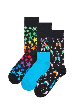 Drei Paar Socken: ein Paar mit Regenbogensternen, ein einfarbiges blaues Paar und ein weiteres Paar schwarz mit bunten Champagnergläsern. Aus Stoff gefertigt, mit lebhaften Designs.