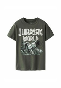 T-shirt en coton vert avec un graphisme "Jurassic World" présentant des dinosaures, des illustrations détaillées et un texte blanc en gras. Manches courtes.