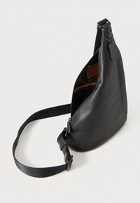 Schwarze Leder Slingtasche mit glatter Textur, Reißverschlussverschluss und braunter Innenauskleidung. Verfügt über einen verstellbaren Riemen und Hardware-Akzente.