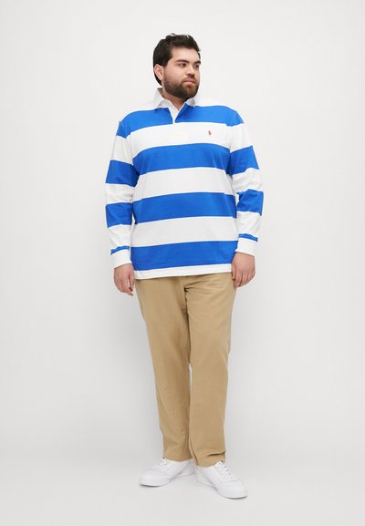 Langermet polo skjorte med blå og hvite horisontale striper, laget av bomull, med krage. Brukt med beige bukser og hvite sneakers.