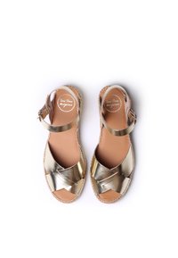 Gold metallic espadrille sandals with cross-strap design, leather lining, and ankle buckle. Jute sole with stitched detail.