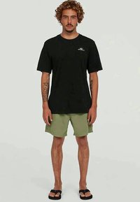 Tricou negru cu maneci scurte, cu un logo alb, asortat cu pantaloni scurți verzi și sandale negre. Are o croială lejeră, material din bumbac și un stil casual.
