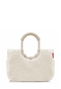 Borsa in finta pelliccia color crema con manico beige arrotondato, caratterizzata da una texture morbida e una forma rettangolare semplice. Etichetta con logo rosso sul lato.