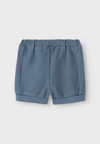 Blå ribbede shorts med elastisk talje og opfoldede manchetter. Blød tekstur med lodrette striber og en afslappet pasform.