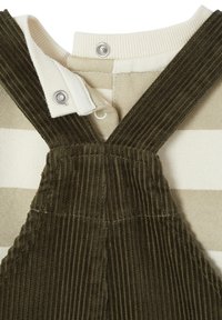 Cotton overall in dark green corduroy with a striped cream and beige top. Features snap closures with silver hardware. Textured fabric.