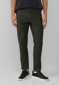 Olijfgroene broek van een katoenmix. Slanke pasvorm met een vlakke voorkant, gecombineerd met zwarte sneakers en zonder zichtbare patronen of accenten.