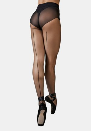 Vrouw in zwarte doorzichtige panty met een naad aan de achterkant en zwarte balletschoenen op spitzen, staand op haar tenen tegen een effen achtergrond.