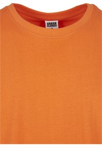 Tricou din bumbac portocaliu cu guler rotund, având o textură netedă și cusături minime. Eticheta spune "URBAN CLASSICS", mărimea M.