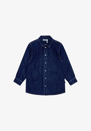 Chemise en denim bleu foncé avec un col classique, des manches longues, une fermeture par boutons et une texture subtile, avec une étiquette sur le côté inférieur.