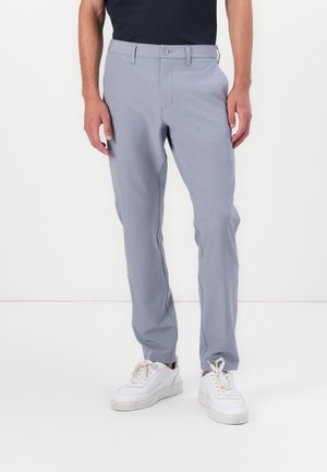Gray slim-fit trousers with a smooth texture, zipper fly, button closure, and subtle side pockets, paired with white sneakers.