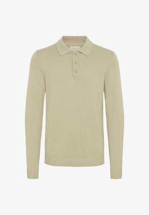 Šviesiai rudas ilgas rankovėmis polo megztinis, pagamintas iš skilinėtos megztos medžiagos, su trims mygtukais priekyje ir skilinėtais rankogaliais bei apačia. Klasikinio tipo apykaklė.