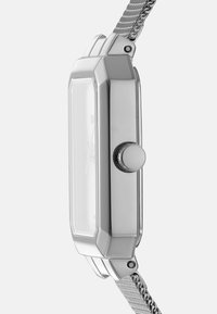 Zilveren rechthoekig horloge met een gepolijst metalen kast, een gestructureerde meshband en een ronde kroon aan de zijkant. Transparante beschermende glazen wijzerplaat.