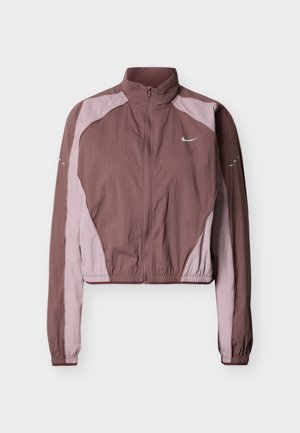 Krótka, lekka kurtka w ciemnym odcieniu mauve i jasnoróżowym, z wysokim kołnierzem, zamkiem błyskawicznym, elastycznymi mankietami oraz subtelnym logo na wysokości klatki piersiowej.