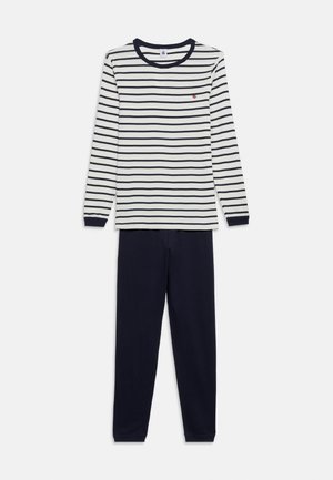 Hosszú ujjú fehér ing fekete vízszintes csíkokkal és fekete kerek gallérral, egyszínű fekete hosszú nadrággal laposan elrendezve.