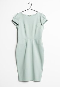 Robe ajustée à manches courtes de couleur vert pâle avec des détails de couture, suspendue sur un cintre noir contre un fond blanc.
