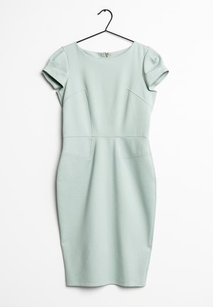Robe ajustée à manches courtes de couleur vert pâle avec des détails de couture, suspendue sur un cintre noir contre un fond blanc.