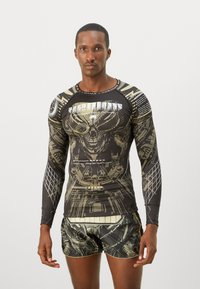 Langærmet kompressionsskjorte og shorts i sort med et metallic guld grafisk print, der har intrikate designs og textelementer.