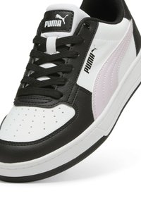 Zapatillas PUMA con parte superior de cuero negro, acentos en blanco y rosa claro, puntera perforada y cordones negros. Presenta una suela de goma texturizada.