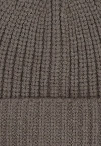 Gray knitted beanie; features a ribbed texture throughout. Soft, warm material with a rounded top and folded cuff.