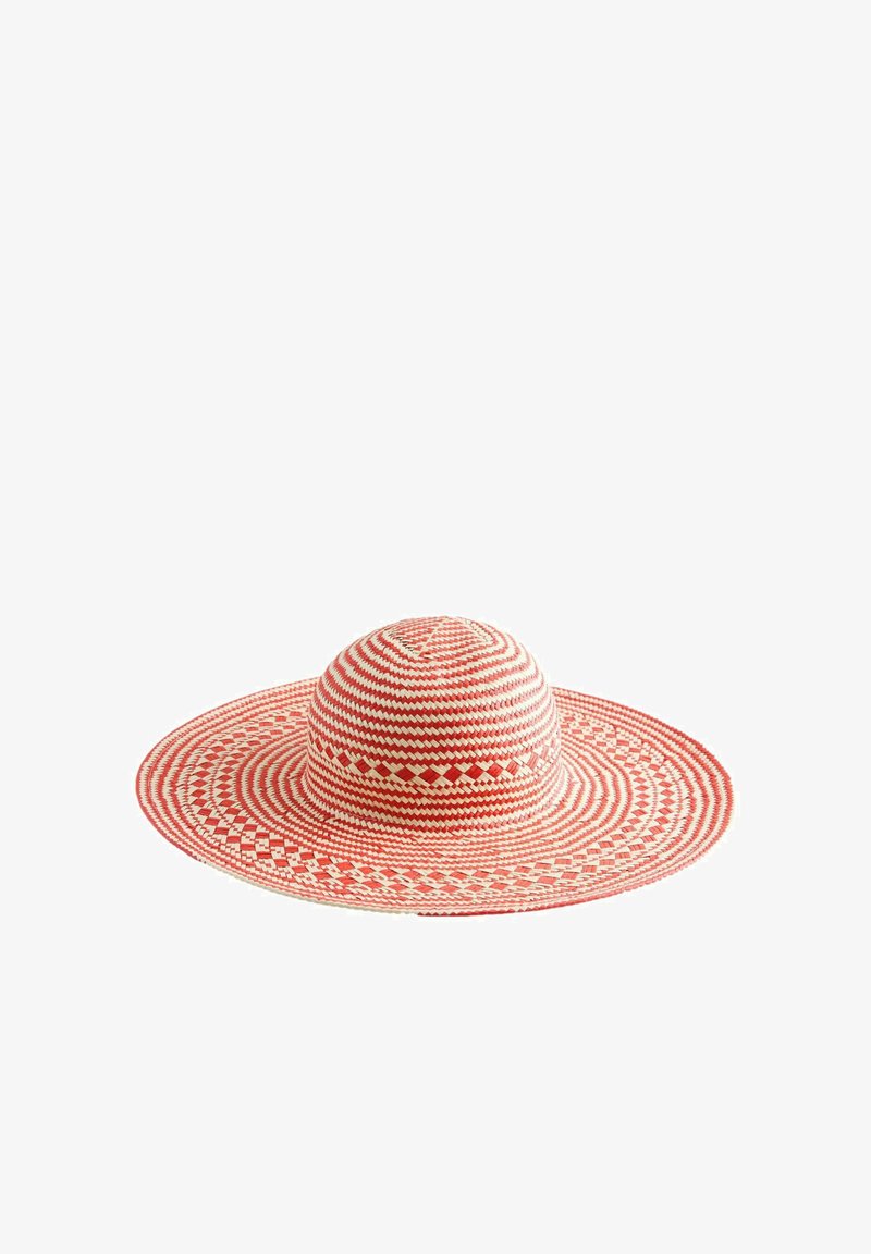 Sombrero tejido de ala ancha con patrones alternos en rojo y blanco, con corona plana y diseños geométricos intrincados.
