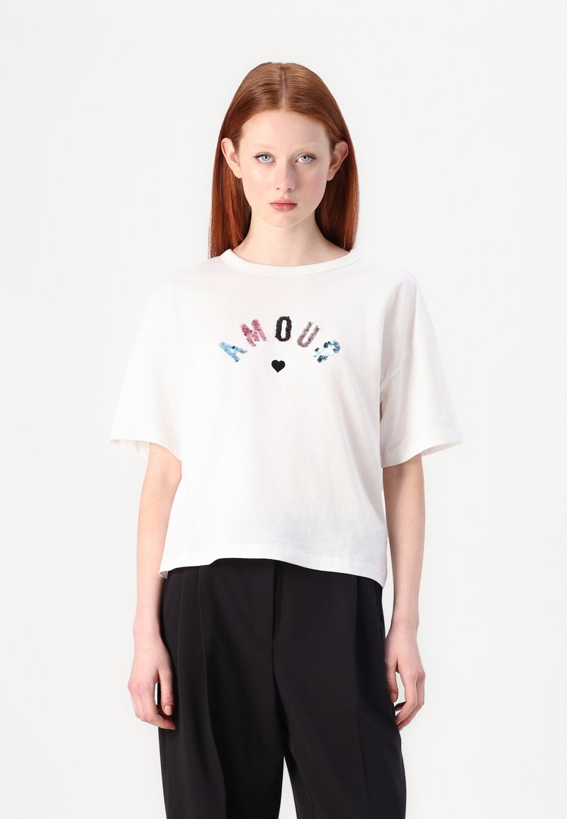 Balta medvilnin�ė t-shirt marškinėliai su trumpomis rankovėmis, su daugiakcoloriais blizgučiais užrašais "AMOUR?" ir maža širdies grafinė композиция centre.