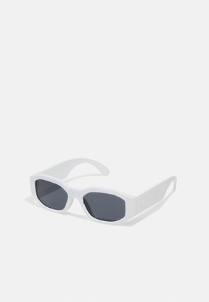 Lunettes de soleil rectangulaires blanches avec des verres foncés, une finition mate lisse et des branches épaisses au design angulaire.