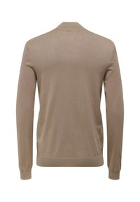 Cardigan beige a maniche lunghe con una texture liscia, polsini a coste e colletto a scialle. Presenta un'etichetta laterale discreta vicino all'orlo.