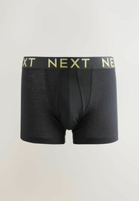 Boxer shorts negros hechos de una tela suave, con una amplia cinturilla elástica que lleva el logo "NEXT" en amarillo contraste.