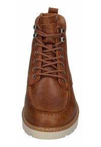 Botas de tobillo de cuero marrón con punta redondeada, ojales metálicos y diseño de cordones. Presenta pespuntes en contraste en tono beige y una suela de goma blanca.