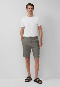 Witte T-shirt met ronde hals, gecombineerd met grijze textuuroverhemd tot de knie en zwarte sandalen, met een knoopsluiting en zijzakken.