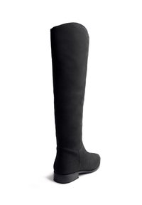 Botas negras de ante por encima de la rodilla con suela plana y textura suave, que presentan una punta redondeada y un diseño sin costuras para una apariencia aerodinámica.