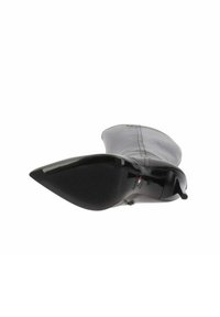 Schwarzer Lederschuh mit spitzem Zehenbereich und glatter Oberfläche, ausgestattet mit einer strukturierten Sohle und einem seitlichen Reißverschluss, entworfen für eine elegante Silhouette.