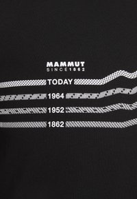 Černé tričko s bílým textem a grafickými čarami. Text obsahuje "Mammut Since 1862," "Dnes," a data, s různými vzory čar.