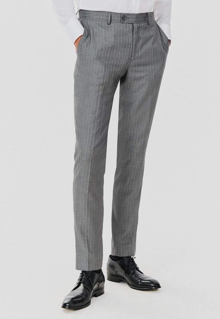 Szare spodnie w prążki o dopasowanym kroju, z płaskim przodem, kieszeniami bocznymi i zapięciem na guzik. Nosi się je z czarnymi butami wizytowymi.
