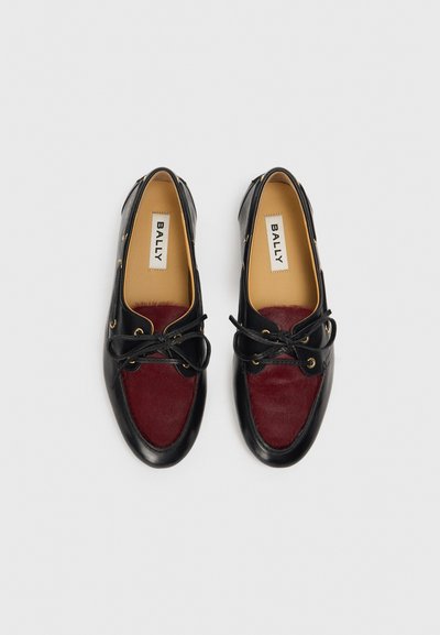 Black leather and burgundy hair-on-hide shoes with rounded toe, golden eyelets, and black laces. Interior features a tan insole.