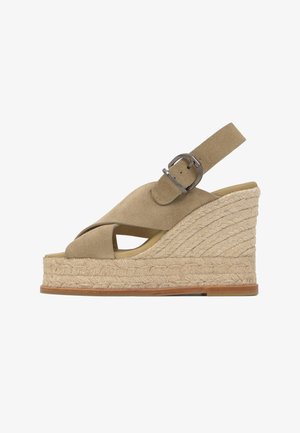 Sandalia de cuña de ante beige con tiras cruzadas, suela plataforma de cuerda tejida y correa de tobillo ajustable con hebilla metálica.