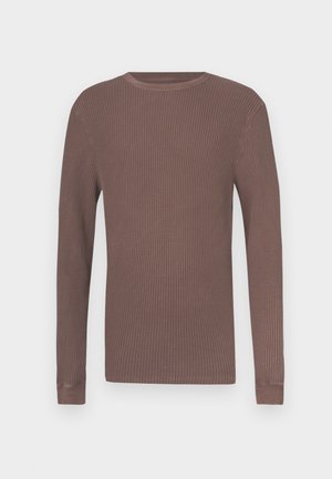 Cămașă maro cu mâneci lungi și dungi, cu decolteu rotund și manșete strânse. Realizată dintr-un material texturat pentru confort și căldură.