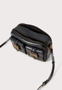 Schwarze Lederhandtasche mit zwei Reißverschlussfächern, goldfarbener Hardware, strukturiertem Finish und abnehmbarem Gurt. Kompaktes, rechteckiges Design.
