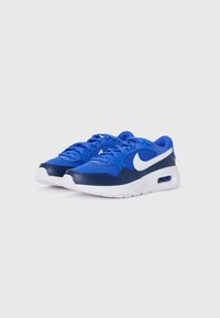 Plave Nike tenisice s kombinacijom tekstila i kožne gornje strane, bijeli swoosh, zaobljena potplat i zračni sustav za ublažavanje udarca u peti.