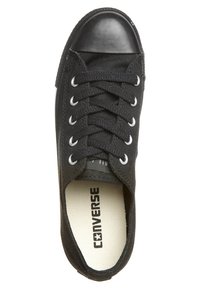 Baskets Converse basses noires avec lacets noirs, œillets en métal, embout en caoutchouc et semelle intérieure blanche marquée du texte "CONVERSE".
