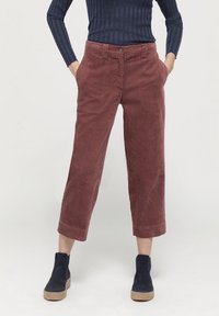 Kostymbyxor i en djup burgundyröd färg, kort längd, med sidfickor och knäppning. Matchade med marinblå ankelkängor.