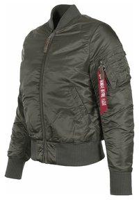 Olive green bomber jacket made of shiny nylon, featuring a front zipper, ribbed cuffs, side pockets, and a red "Remove Before Flight" tag on the sleeve.