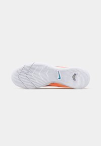Nike jalanõu valge talla värvusega, millel on tekstureeritud kummipind oranžide ja siniste aktsentidega. Profil sisaldab selget tallamustrit.