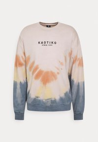 Mikina s tie-dye vzorem v pastelových barvách, zaobleným výstřihem, ribbovanými manžetami a logem uprostřed.